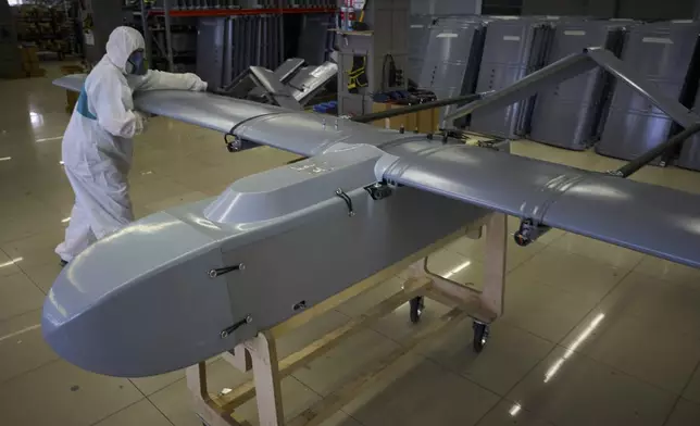A worker inspects a combat drone at Fire Point's secret factory in Ukraine on Monday, Aug. 18, 2025. (AP Photo/Efrem Lukatsky)