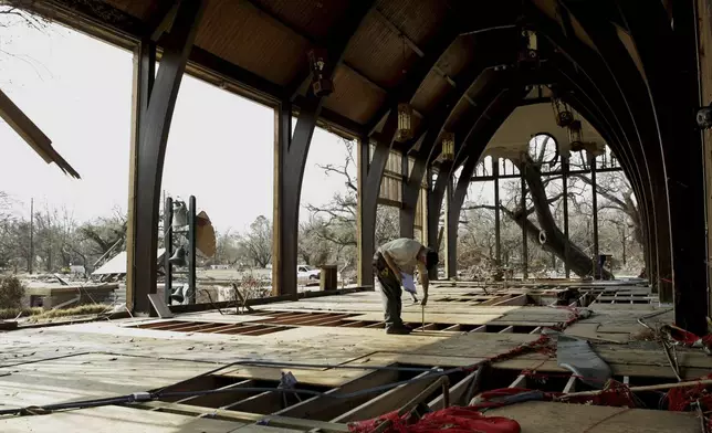 FILE - Structural engineer, Carl Edwards, working for Church Mutual Insurance Company, measures the floor in the gutted Trinity Episcopal Church in Pass Christian, Miss., Sept. 17, 2005. (AP Photo/Steve Helber, File)