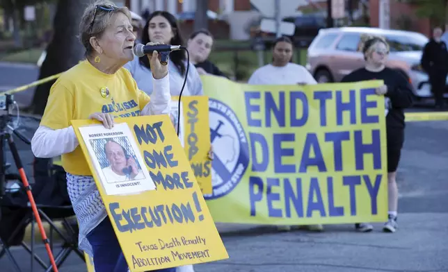 FILE - Gloria Rubac, left, an anti-death penalty activist, speaks during a protest outside the prison where Robert Roberson is scheduled for execution at the Huntsville Unit of the Texas State Penitentiary, Oct. 17, 2024, in Huntsville, Texas. (AP Photo/Michael Wyke)