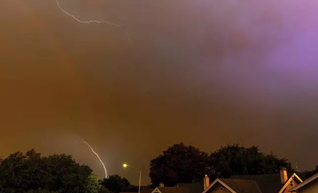 A rainbow is seen as lightning strikes during an early morning storm brought high winds to the area early in Omaha, Neb. on Saturday, Aug. 9, 2025. (Chris Machian/Omaha World-Herald via AP)