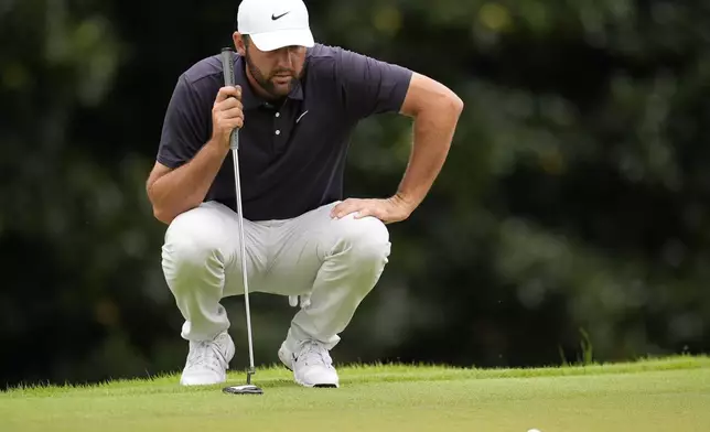 Scottie Scheffler lines up his putt on the second green during the third round of the Tour Championship golf tournament, Saturday, Aug. 23, 2025, in Atlanta. (AP Photo/Mike Stewart)