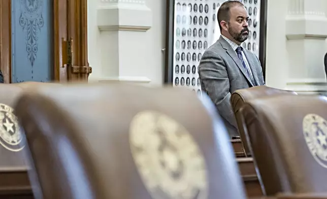 Texas House Rep. Joe Moody, D - El Paso, stands at the back of the House Chambers with empty chairs belonging to House Democrats protesting a redistricting map at the State Capitol, Tuesday, Aug. 5, 2025, in Austin, Texas. (AP Photo/Rodolfo Gonzalez)