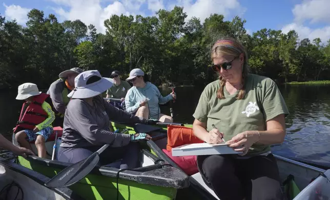 Michelle Jamesson, a volunteer at the SpringsWatch Citizen Science Program, takes in numerous readings by volunteers along the Wekiwa River on Friday, July 18, 2025, in Apopka, Fla. (AP Photo/Marta Lavandier)