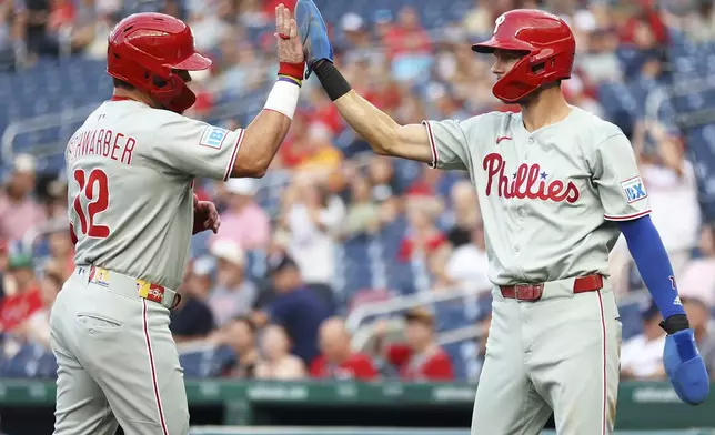 Philadelphia Phillies' Kyle Schwarber celebrates with Philadelphia Phillies' Trea Turner after scoring a run during the first inning of a baseball game against the Washington Nationals, Friday, Aug. 15, 2025, in Washington. (AP Photo/Daniel Kucin Jr.)