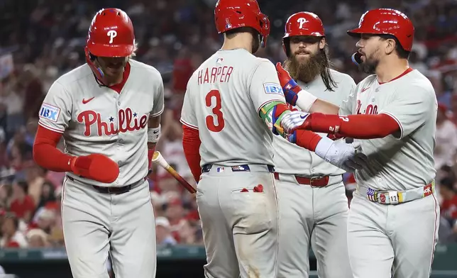Philadelphia Phillies' Kyle Schwarber celebrates with his teammates after hitting a home run during the seventh inning of a baseball game against the Washington Nationals, Friday, Aug. 15, 2025, in Washington. (AP Photo/Daniel Kucin Jr.)