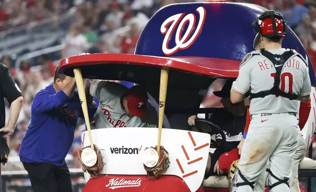 Philadelphia Phillies pitcher Jhoan Duran gets carted off of the field during the ninth inning of a baseball game against the Washington Nationals, Friday, Aug. 15, 2025, in Washington. (AP Photo/Daniel Kucin Jr.)