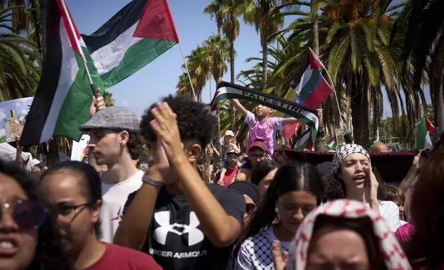 Demonstrators march ahead of the launch of a civilian flotilla bound for Gaza, aiming to break the Israeli blockade and deliver humanitarian aid in Barcelona, Spain, Sunday, Aug. 31, 2025. (AP Photo/Emilio Morenatti)