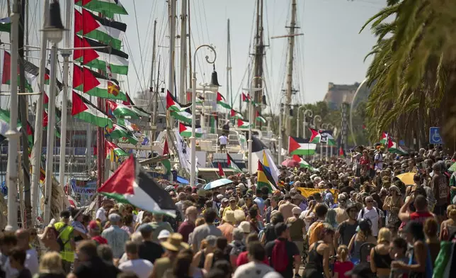 People crowd the dock ahead of the launch of a civilian flotilla bound for Gaza, aiming to break the Israeli blockade and deliver humanitarian aid in Barcelona, Spain, Sunday, Aug. 31, 2025. (AP Photo/Emilio Morenatti)