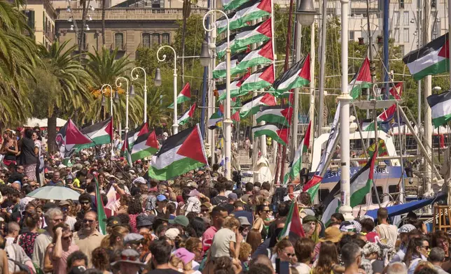 People crowd the dock ahead of the launch of a civilian flotilla bound for Gaza, aiming to break the Israeli blockade and deliver humanitarian aid in Barcelona, Spain, Sunday, Aug. 31, 2025. (AP Photo/Emilio Morenatti)