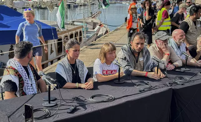 Swedish climate activist Greta Thunberg, center, speaks during a news conference ahead of the launch of a civilian flotilla bound for Gaza, aiming to break the Israeli blockade and deliver humanitarian aid in Barcelona, Spain, Sunday, Aug. 31, 2025. (AP Photo/Hernan Munoz)