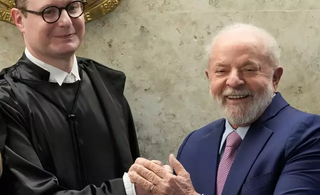 FILE - Brazil's President Luiz Inacio Lula da Silva, right, and new Supreme Court Justice Cristiano Zanin, pose for photos after his swearing-in ceremony, in Brasilia, Brazil, Aug. 3, 2023. (AP Photo/Eraldo Peres, File)