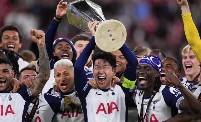 FILE - Tottenham's Son Heung-min holds the trophy aloft as he celebrates with teammates after winning the Europa League final soccer match against Manchester United at the San Mames Stadium in Bilbao, Spain, on May 21, 2025. (AP Photo/Manu Fernandez, File)