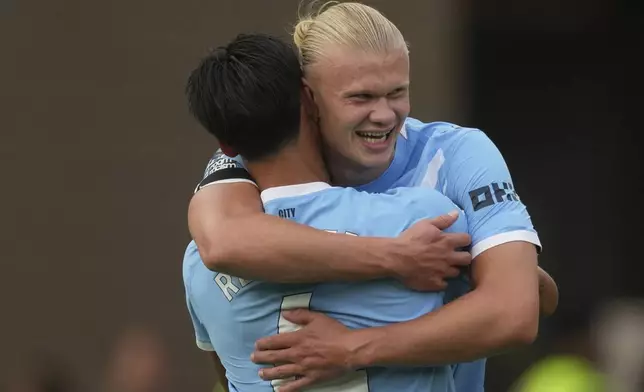 Manchester City's Erling Haaland, right, celebrates with Manchester City's Tijjani Reijnders after scoring his sides third goal during the English Premier League soccer match between Wolverhampton Wanderers and Manchester City at Molineux Stadium, Wolverhampton, England, Saturday, Aug. 16, 2025. (AP Photo/Dave Shopland)