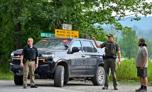Police officers block the street leading to where two Pennsylvania state troopers were ambushed and shot Thursday, Aug. 7, 2025, near the village of Thompson, in Susquehanna County, Pa. (AP Photo/Aimee Dilger)