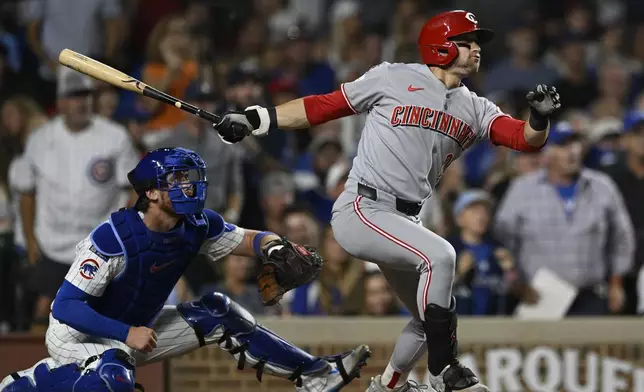 Cincinnati Reds' TJ Friedl, right, watches his RBI single during the seventh inning of a baseball game against the Chicago Cubs, Monday, Aug. 4, 2025, in Chicago. (AP Photo/Paul Beaty)