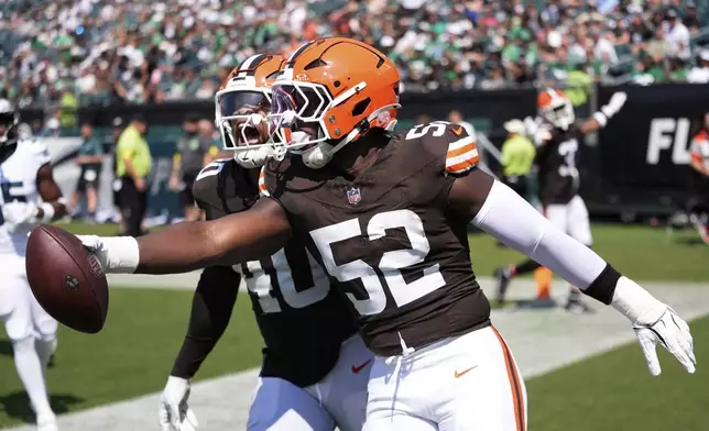 Cleveland Browns defensive end KJ Henry (52) celebrates his interception for a touchdown with Browns linebacker Nathaniel Watson (40) during the second half of an NFL preseason football game against the Philadelphia Eagles on Saturday, Aug. 16, 2025, in Philadelphia. (AP Photo/Chris Szagola)