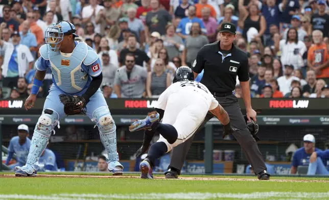 Detroit Tigers' Javier Báez slides safely into home plate during the third inning of a baseball game Kansas City Royals Saturday, Aug. 23, 2025, in Detroit. (AP Photo/Josh Boland )