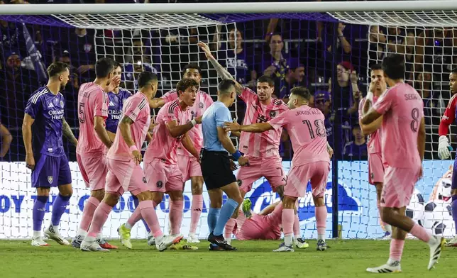 Inter Miami players an surround official, center, while arguing about a corner kick against Orlando City during the first half of an MLS soccer match, Sunday, Aug. 10, 2025, in Orlando, Fla. (AP Photo/Kevin Kolczynski)