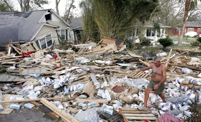 FILE - Moe Llaren makes his way through the debris of destroyed homes as he tries to find his own house in Gulfport, Miss., on Aug. 31, 2005. (AP Photo/Denis Paquin, File)