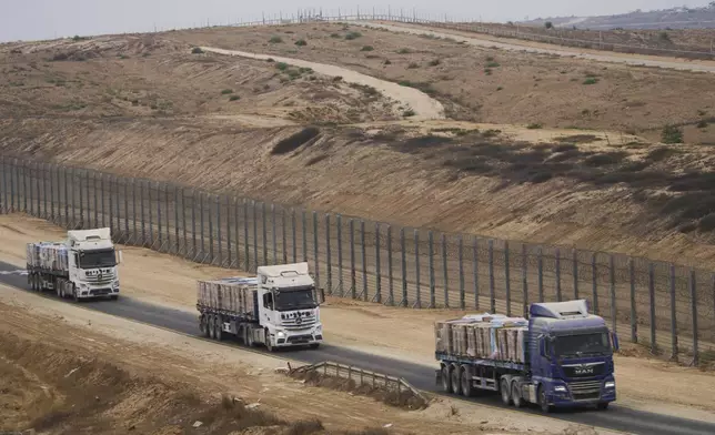 Trucks carrying humanitarian aid for Palestinians in Gaza move along the border with Gaza Strip in southern Israel, Wednesday, Aug. 13, 2025. (AP Photo/Ariel Schalit)