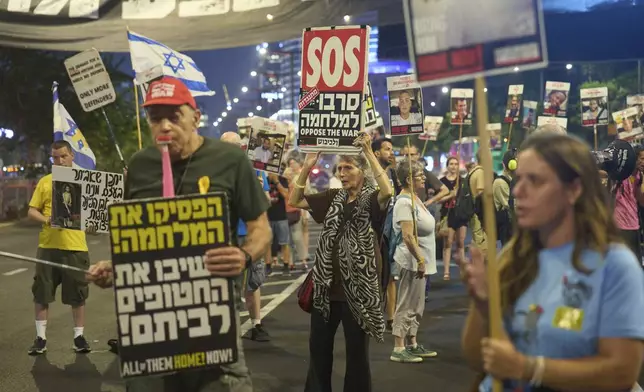 People take part in a protest demanding the end of the war and immediate release of hostages held by Hamas in the Gaza Strip, in Tel Aviv, Israel, Tuesday, Aug. 12, 2025. (AP Photo/Ariel Schalit)