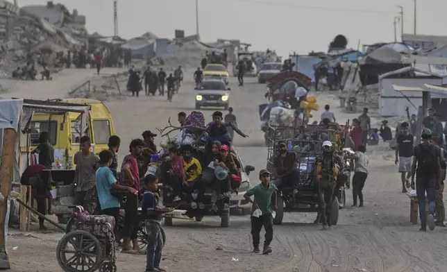Displaced Palestinians travel on carts and vehicles through a makeshift camp along the beach in Gaza City, Sunday, Aug. 10, 2025. (AP Photo/Jehad Alshrafi)
