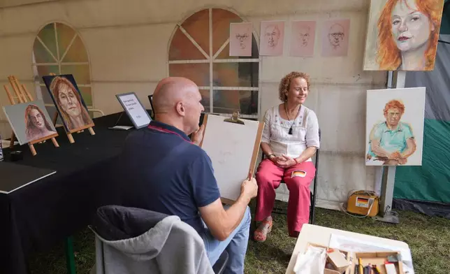 A participant has her portrait done during the Red Head Days festival in Tilburg, Netherlands, Saturday, Aug. 30, 2025. (AP Photo/Virginia Mayo)