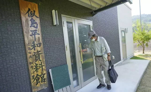 Kazuo Miyazaki, a local historian and head of the Ninoshima History Volunteer Guide Association, opens his peace information center on Tuesday, July 8, 2025, at Ninoshima in Hiroshima, western Japan. (AP Photo/Eugene Hoshiko)