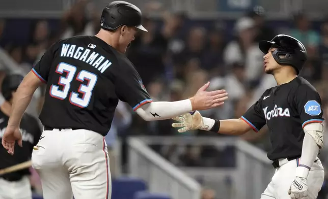 Miami Marlins' Javier Sanoja, right, celebrates after hitting a two-run homer that also brought home Eric Wagaman, in the fifth inning of a baseball game against the New York Yankees, Friday, Aug. 1, 2025, in Miami. (AP Photo/Rebecca Blackwell)