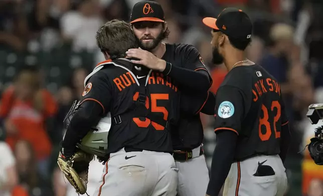 Baltimore Orioles starting pitcher Brandon Young, center, is greeted by catcher Adley Rutschman (35) after winning a baseball game against the Houston Astros in Houston, Friday, Aug. 15, 2025. (AP Photo/Ashley Landis)