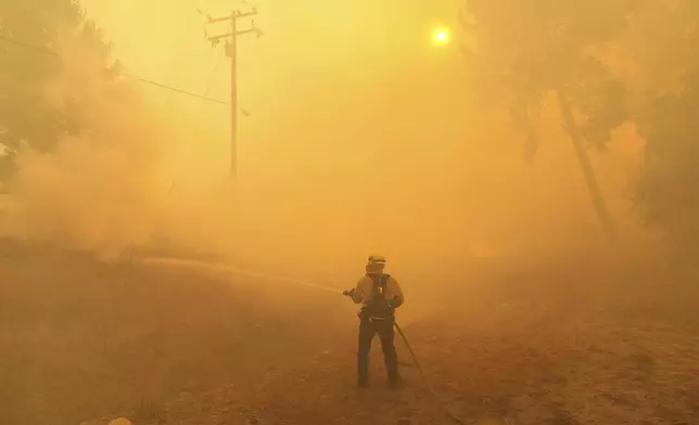 A firefighter battles the Canyon Fire on Thursday, Aug. 7, 2025, in Halsey Canyon, Calif. (AP Photo/Marcio Jose Sanchez)