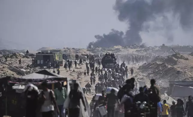 Palestinians carry sacks of flour unloaded from a humanitarian aid convoy on the outskirts of Beit Lahiya, northern Gaza Strip, Saturday, Aug, 23, 2025. (AP Photo/Abdel Kareem Hana)