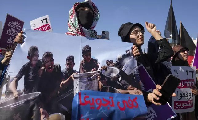 Israeli and Palestinian activists take part in a protest calling for the end of the war and an end to starvation in the Gaza Strip, as they gather in Tel Aviv, Israel, Saturday, Aug. 23, 2025. (AP Photo/Maya Levin)