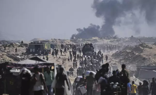Palestinians carry sacks of flour unloaded from a humanitarian aid convoy on the outskirts of Beit Lahiya, northern Gaza Strip, Saturday, Aug, 23, 2025. (AP Photo/Abdel Kareem Hana)