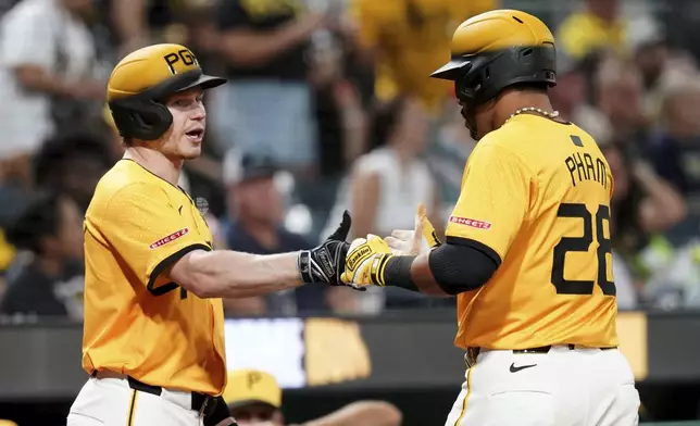 Pittsburgh Pirates' Tommy Pham, right, is greeted by Jack Suwinski, left, after hitting a two-run home run during the sixth inning of a baseball game against the Colorado Rockies, Friday, Aug. 22, 2025, in Pittsburgh. (AP Photo/Matt Freed)