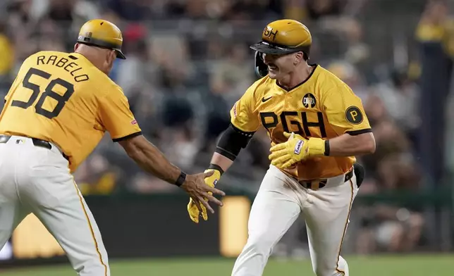 Pittsburgh Pirates' Spencer Horwitz, right, is greeted by third base coach Mike Rabelo, left, after hitting a home run during the sixth inning of a baseball game against the Colorado Rockies, Friday, Aug. 22, 2025, in Pittsburgh. (AP Photo/Matt Freed)