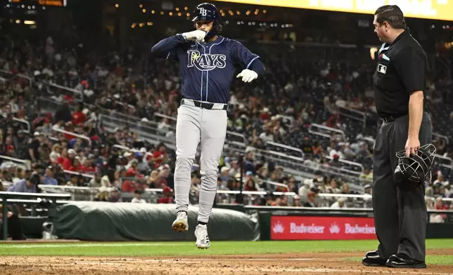 Tampa Bay Rays' Everson Pereira, left, celebrates after his home run near to home plate umpire Derek Thomas, right, during the fifth inning of a baseball game against the Washington Nationals, Friday, Aug. 29, 2025, in Washington. (AP Photo/Nick Wass)