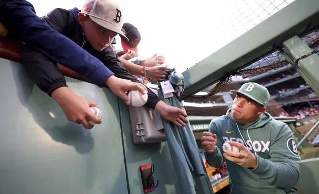 Boston Red Sox third baseman Nate Eaton, right, asks for a pen to sign a ball for a fan before a baseball game against the Pittsburgh Pirates, Friday, Aug. 29, 2025, in Boston. (AP Photo/Mark Stockwell)