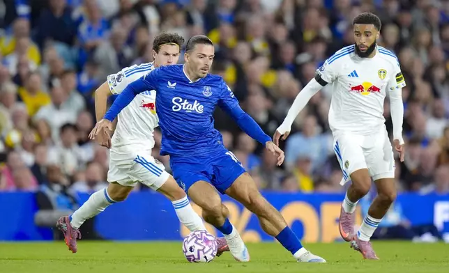 From left to right, Leeds United's Brenden Aaronson, Everton's Jack Grealish and Leeds United's Jayden Bogle battle for the ball during an English Premier League soccer match between Leeds United and Everton at Elland Road in Leeds, England, Monday, Aug. 18, 2025. (Danny Lawson/PA via AP)