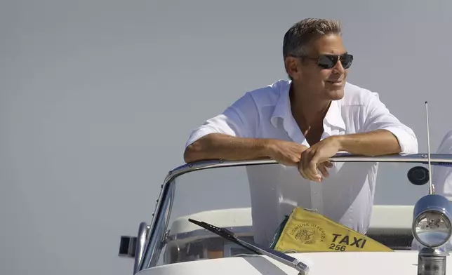 FILE - George Clooney arrives in Venice, Italy on a taxi boat for the 65th Venice Film Festival, Tuesday Aug. 26, 2008. (AP Photo/Joel Ryan, File)