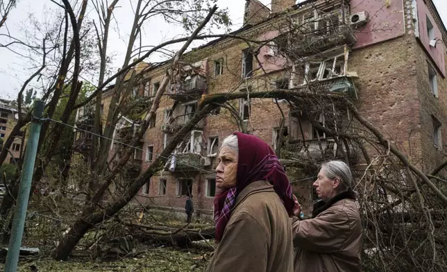 Local women stand in front of a residential building heavily damaged by a Russian strike in Kyiv, Ukraine, on Thursday, July 31, 2025. (AP Photo/Evgeniy Maloletka)
