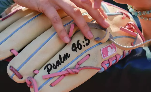 A player holds her glove in the dugout during the first day of tryouts for the Women's Professional Baseball League, Friday, Aug 22, 2025, at the Washington Nationals Youth Baseball Academy in Washington. (AP Photo/Julia Demaree Nikhinson)