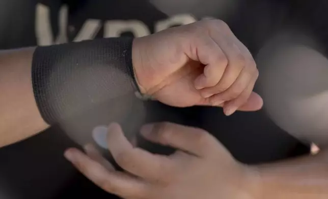 A player wraps tape around her wrist during the second day of tryouts for the Women's Professional Baseball League, Saturday, Aug. 23, 2025, at the Washington Nationals Youth Baseball Academy in Washington. (AP Photo/Julia Demaree Nikhinson)