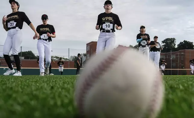 Summer Hill (23), Celicia Wilken (1), Amanda Gianelloni (10), Denae Benites (16), SarahBeaulieu (37) and other players warm up during the third day of tryouts for the Women's Professional Baseball League, Sunday, Aug. 24, 2025, at the Washington Nationals Youth Baseball Academy in Washington. (AP Photo/Julia Demaree Nikhinson)