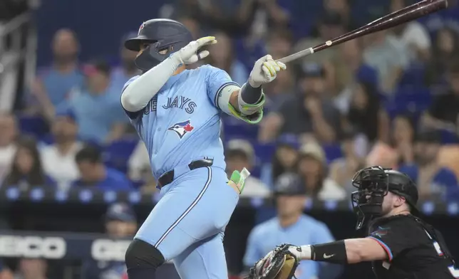 Toronto Blue Jays' Bo Bichette hits a double during the first inning of a baseball game against the Miami Marlins, Friday, Aug. 22, 2025, in Miami. (AP Photo/Marta Lavandier)