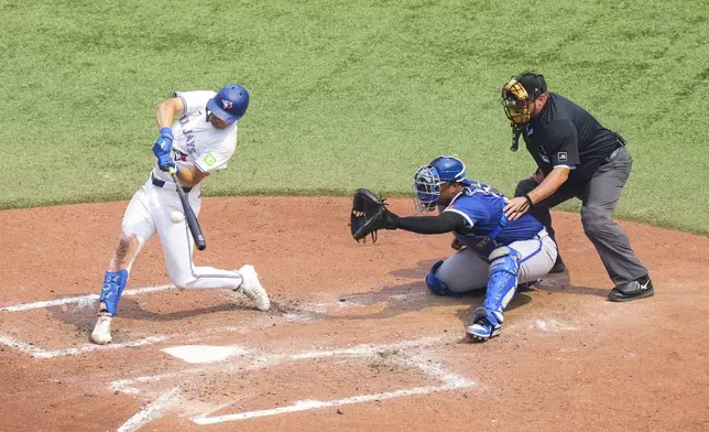 Toronto Blue Jays' Joey Loperfido hits a RBI single in front of Kansas City Royals catcher Salvador Perez during the fifth inning of a baseball game in Toronto on Sunday Aug. 3, 2025. (Chris Young/The Canadian Press via AP)