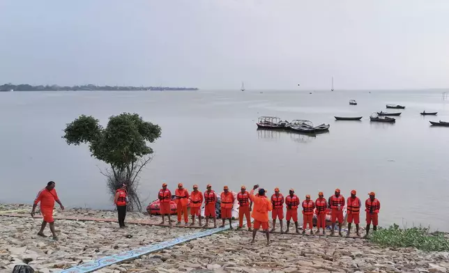 A team leader briefs members of India's National Disaster Response Force (NDRF) on rescue of residents from the flooded areas along the banks of the river Ganga following heavy monsoon rains, in Prayagraj, India, Tuesday, Aug. 5, 2025. (AP Photo/Rajesh Kumar Singh)