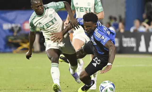 Austin FC's Osman Bukari, left, tackles CF Montreal's Dante Sealy (25) during the second half of an MLS soccer game in Montreal, Saturday, Aug. 23, 2025. (Graham Hughes/The Canadian Press via AP)