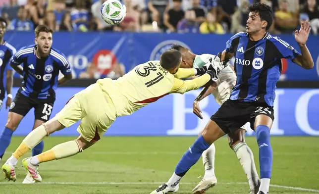 Austin FC's Myrto Uzuni, second from right, scores against CF Montreal goalkeeper Thomas Gillier (31) as Montreal's Efrain Morales (24) defends during first-half MLS soccer match action in Montreal, Saturday, Aug. 23, 2025. (Graham Hughes/The Canadian Press via AP)