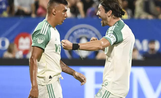 Austin FC's Myrto Uzuni, left, celebrates after his goal against CF Montreal with teammate Ilie Sanchez (6) during first-half MLS soccer match action in Montreal, Saturday, Aug. 23, 2025. (Graham Hughes/The Canadian Press via AP)